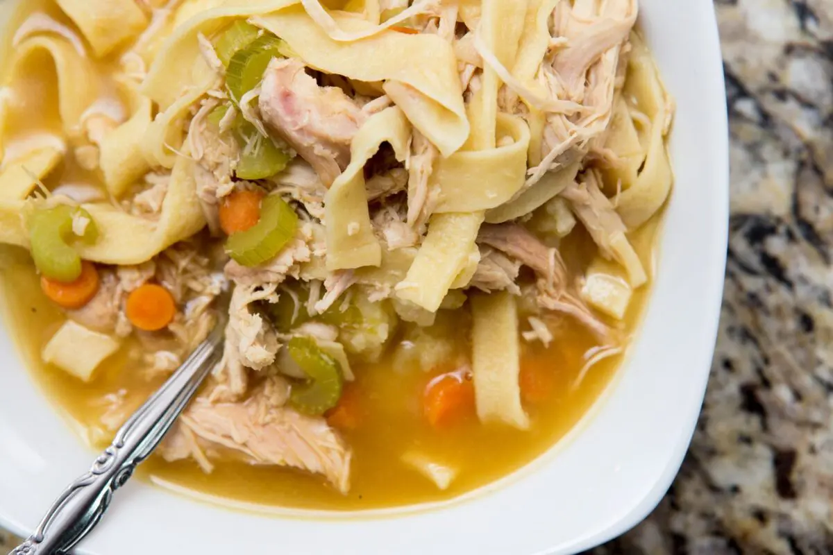 Turkey noodle soup served over mashed potatoes in a bowl