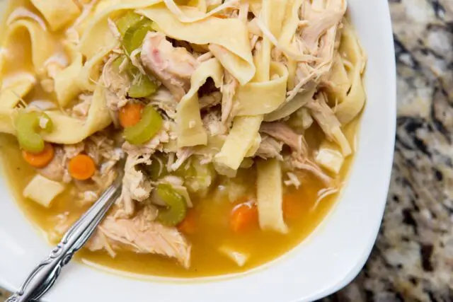 Turkey noodle soup served over mashed potatoes in a bowl