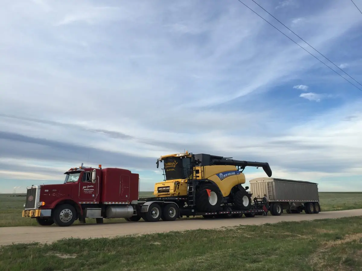 Semi truck hauling combine.