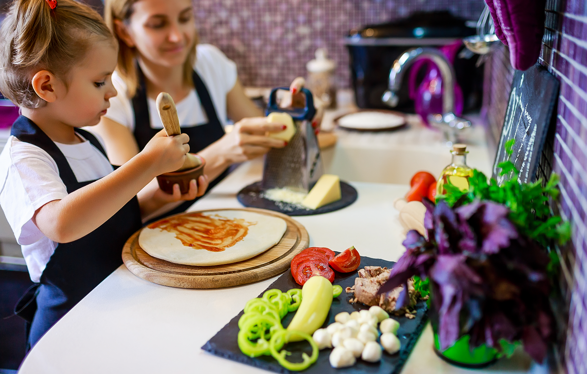 Photo: Happy family cooking pizza together in the kitchen.