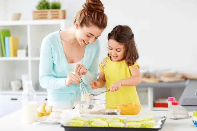 Photo: Mom cooking with kids in the kitchen.