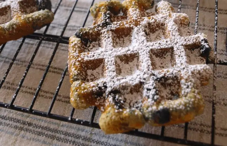 Blueberry Muffles dusted with powdered sugar on a wire cooling rack