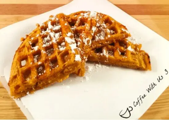Sweet potato waffles with powdered sugar on parchment paper