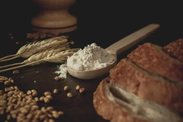 Photo: Bread, flour and wheat on table.