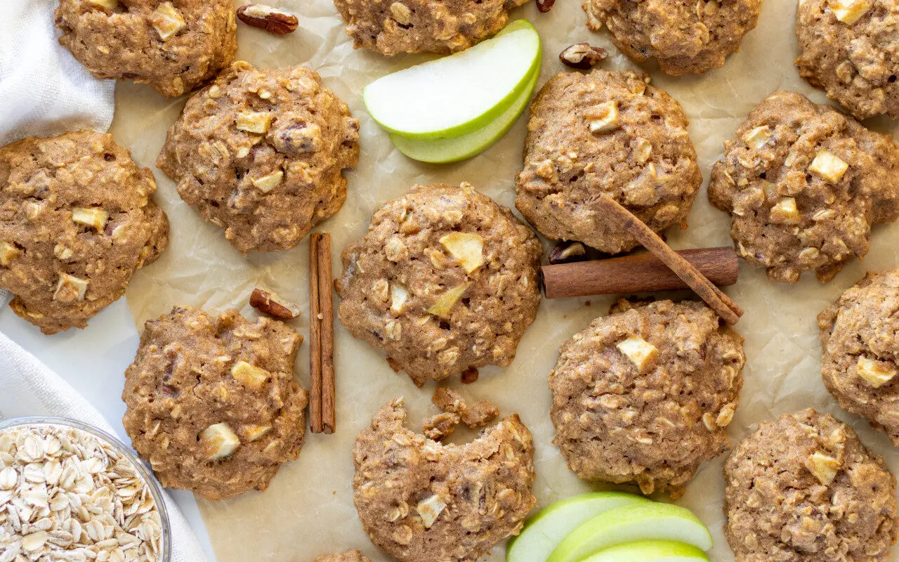 Apple Cinnamon Breakfast Cookies on a tray with apple slices and cinnamon sticks.