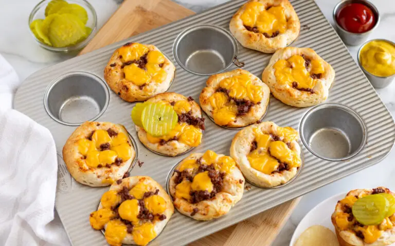 Cheeseburger Cups | Eat Wheat Cheeseburger cups baked in a muffin tin with pickles on the side for serving.