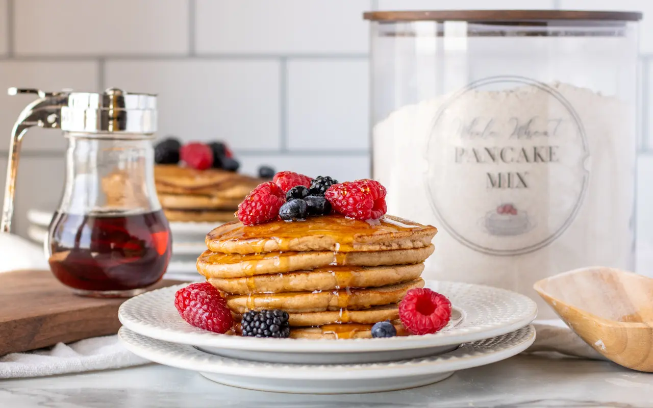 Whole Wheat Pancake Mix with whole wheat pancakes and fruit on a plate.