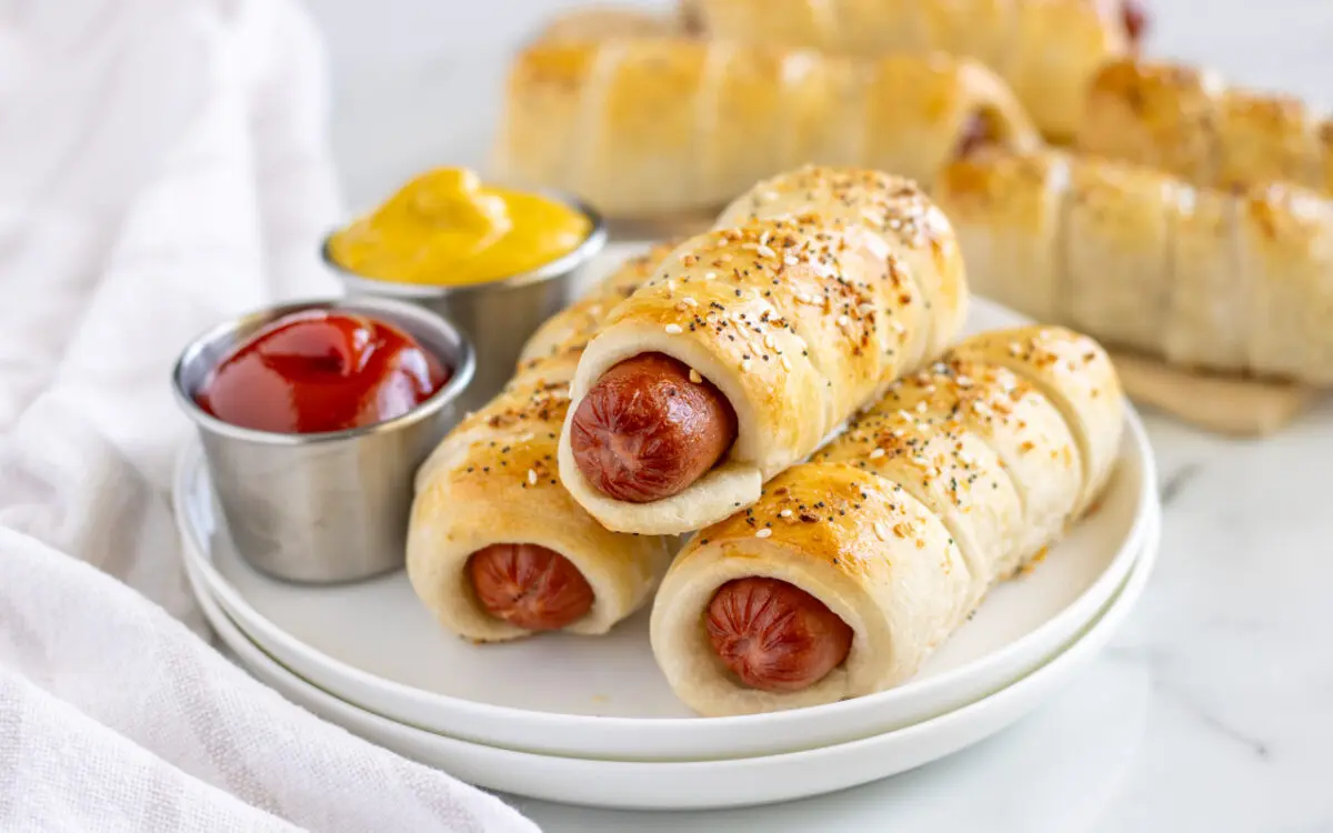 Full Size Pigs in a Banket stacked on a plate with dipping sauce on the side.