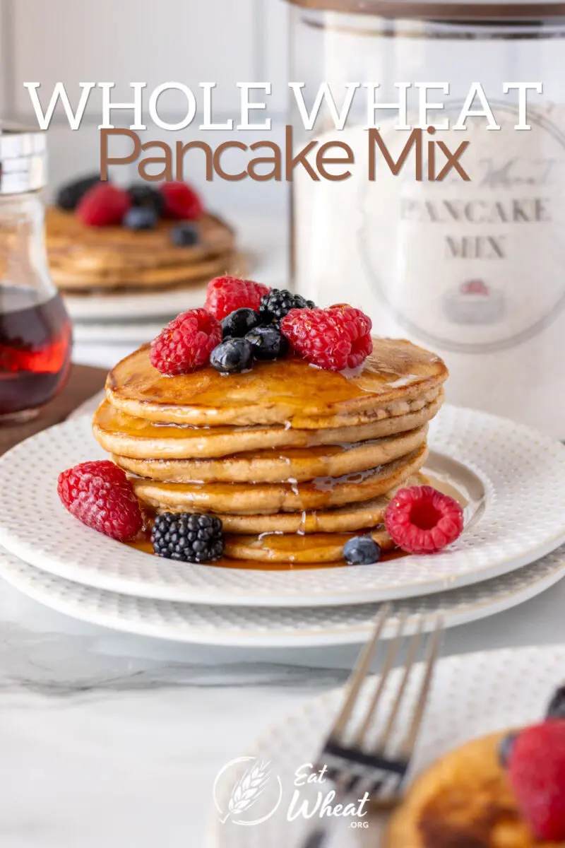 Whole Wheat Pancake Mix in the background with pancakes and fruit on a plate with the text "Whole Wheat Pancake Mix" over the top.
