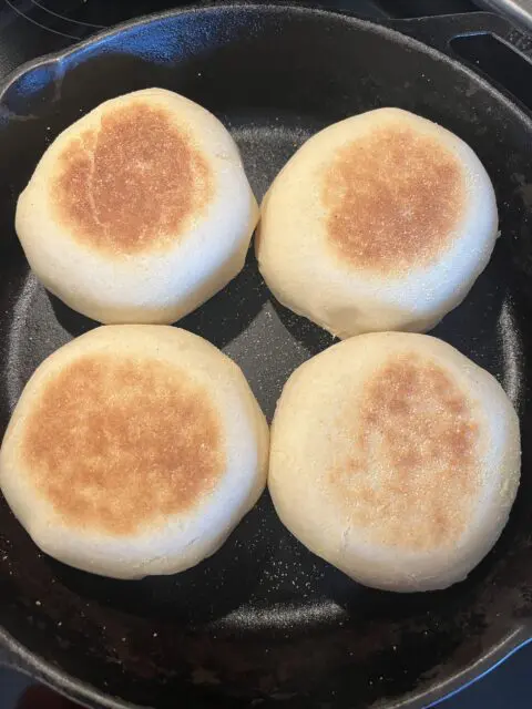 Bread Machine English Muffins in a pan after being baked in the pan. 