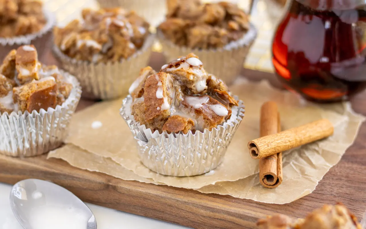 French toast muffins on a wooden board with cinnamon sticks in the background.