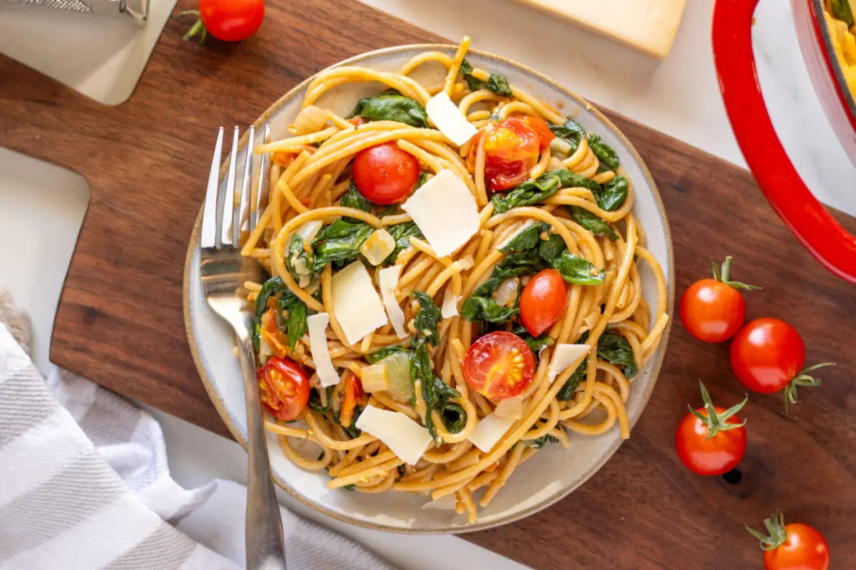 30-minute whole wheat garlic pasta in a dish with tomatoes around.
