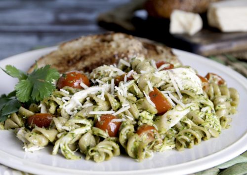 Cilantro Pesto Pasta with Chicken served with whole wheat toast and a sprig of basil