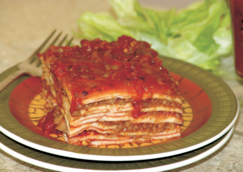 Layered Enchilada Casserole served on plates with a fork