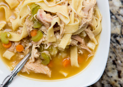 Turkey noodle soup served over mashed potatoes in a bowl
