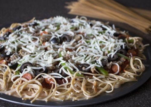 Whole grain spaghetti pizza ready to go in the oven
