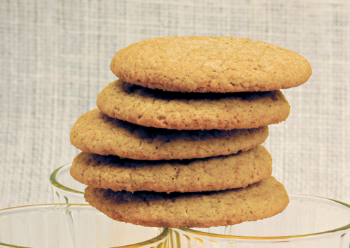 Whole wheat sugar cookies stacked on three glasses filled with orange juice