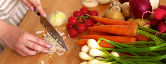 Photo: Hands chopping vegetables with knife.