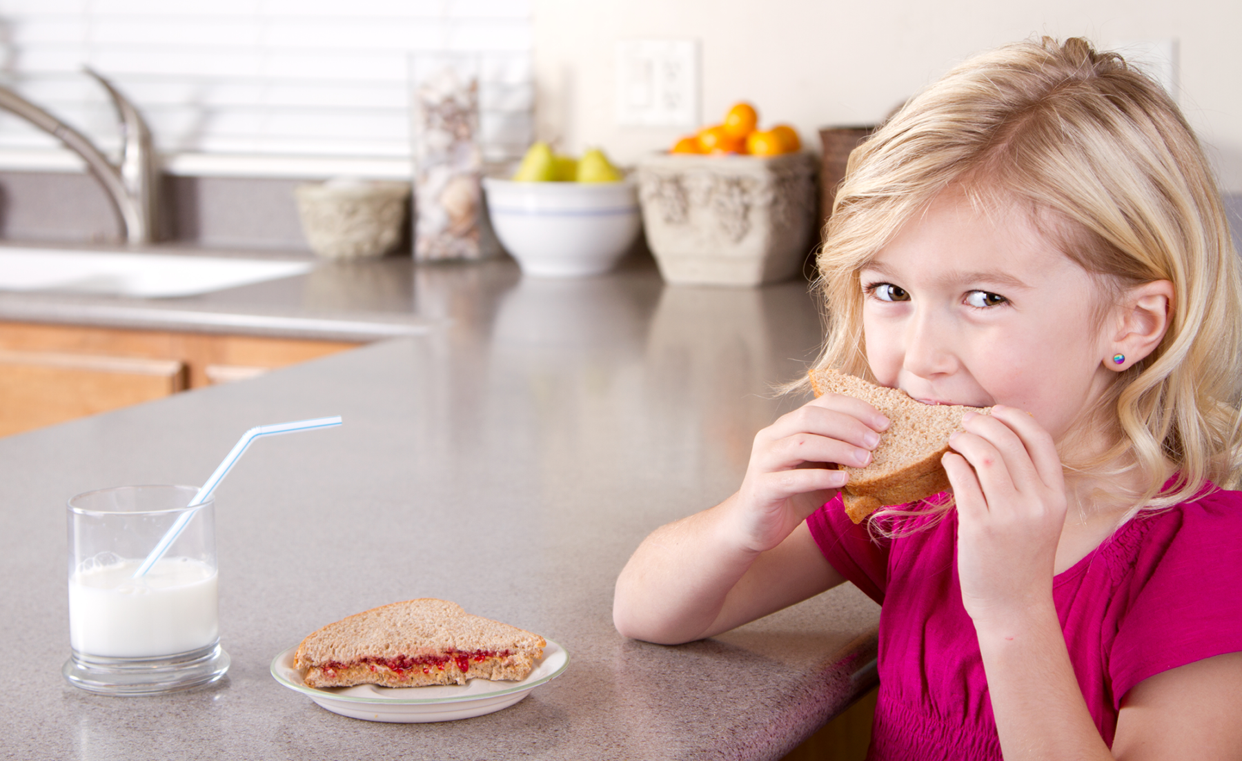 Photo: Girl eating whole grain sandwich.