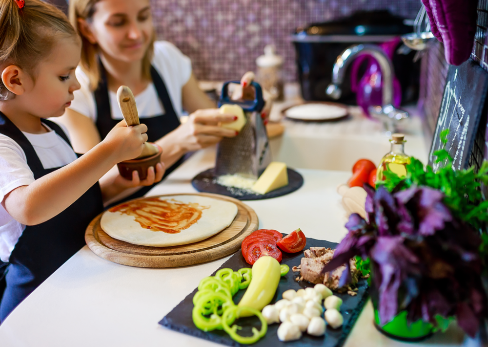 Photo: Happy family cooking pizza together in the kitchen.
