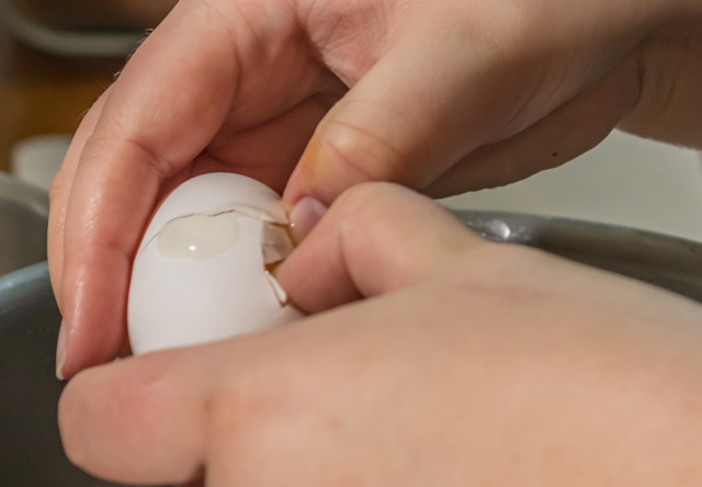 Photo: Hands cracking egg.