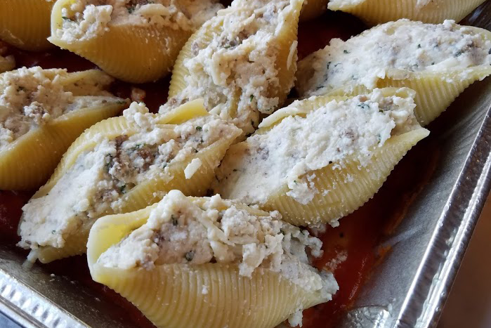 Photo: Stuffed pasta shells in pan.