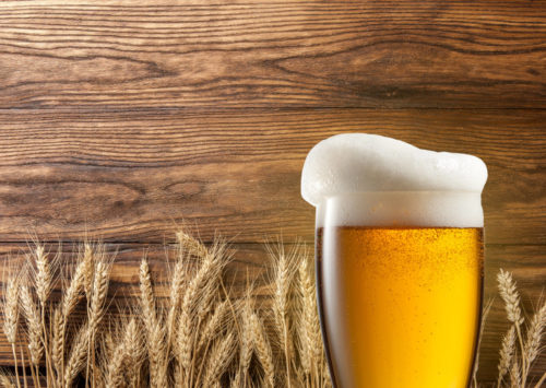 Wheat beer in front of wheat and wood background