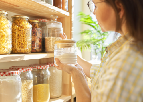 Image: Woman selecting shelf-stable items in pantry.