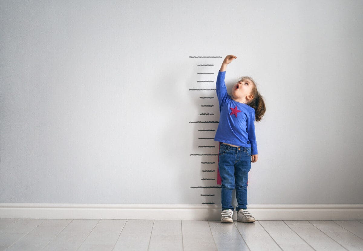 Photo: Girl in front of growth chart.